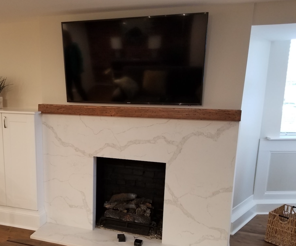 Marble fireplace surround with wall-mounted TV and white built-in cabinets